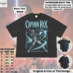 May include: Black boxy tee with a Captain Rex graphic and blue energy effects. The shirt has the text "CAPTAIN REX" and a size chart. The design is by the original artist. The tee is oversized and cropped below the waist.