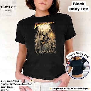 May include: Black youth t-shirt featuring the Indiana Jones movie logo and a graphic of the character. The shirt includes the text "Indiana Jones" in yellow. The shirt is XS size.