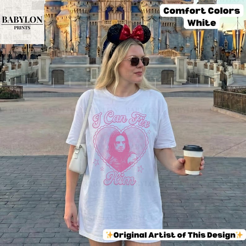 May include: White Comfort Colors t-shirt with a pink heart graphic and the text "I Can Fix Him." The shirt features a portrait and stars. The words "Original Artist of This Design" are at the bottom.