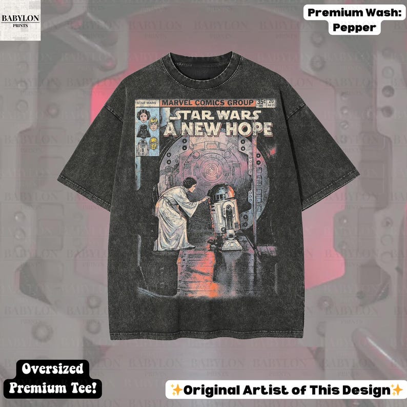 May include: Black oversized premium tee featuring a Star Wars comic book cover design. The graphic includes the text "STAR WARS A NEW HOPE" and images of characters. The shirt has a "Premium Wash: Pepper" finish.