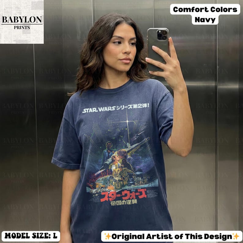 May include: Navy blue Star Wars graphic t-shirt. The shirt features Japanese text and a movie poster design. The shirt is labeled as Comfort Colors and the model is wearing a size L.