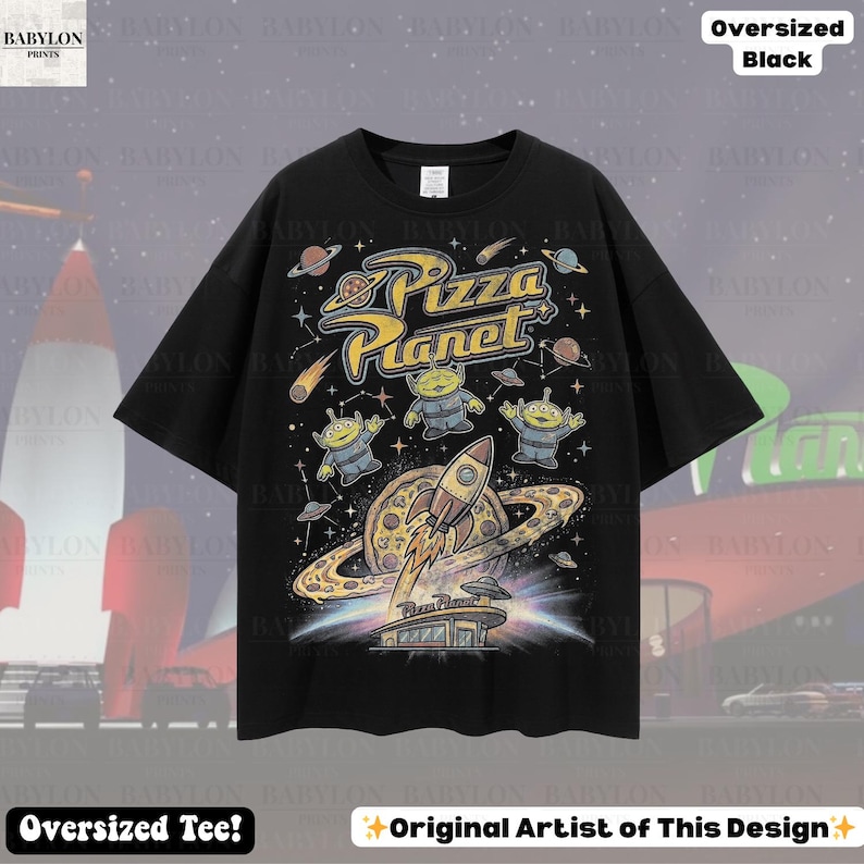 May include: Black oversized tee featuring a colorful Pizza Planet graphic. The design includes the text "Pizza Planet", aliens, a rocket ship, and a pizza planet. The shirt also has the text "Oversized Tee!" and "Original Artist of This Design".