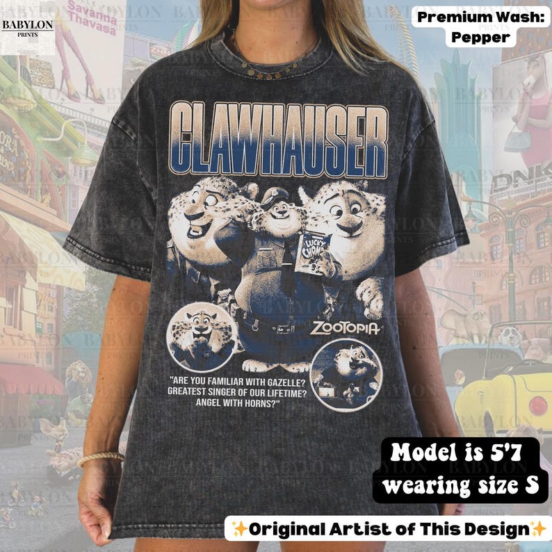 May include: Dark gray t-shirt featuring the word "CLAWHAUSER" in blue, with a graphic of characters from the movie "Zootopia." The shirt includes text from the movie and is a premium wash in pepper color.