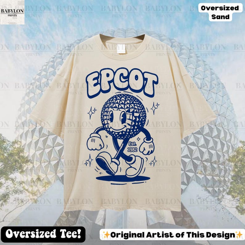 Pu&ograve; includere: T-shirt oversize color sabbia con grafica blu del logo EPCOT, un personaggio sorridente e la scritta "Est. 1982". La maglietta presenta anche le scritte "Oversized Tee!" e "Original Artist of This Design."