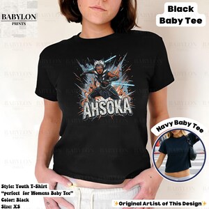 Może przedstawiać: Czarny t-shirt dla dziecka z grafiką Ahsoki Tano z mieczami świetlnymi i napisem "AHSOKA". Koszulka w rozmiarze XS. Projekt oryginalnego artysty.