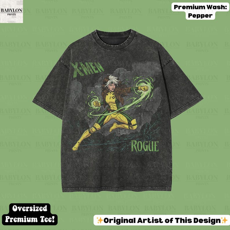 May include: A dark grey oversized t-shirt with a graphic of the X-Men character Rogue in yellow and green. The shirt has the words "X-MEN" and "ROGUE" printed on it. The shirt is labelled "Premium Wash: Pepper" and "Oversized Premium Tee!"