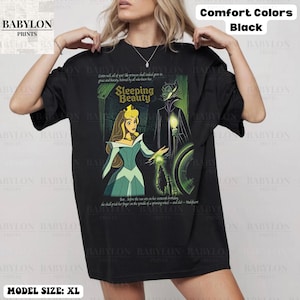 May include: Black XL t-shirt featuring a Sleeping Beauty graphic. The design includes Aurora, Maleficent, and text from the movie. The shirt is labeled "Comfort Colors" and "Babylon Prints".