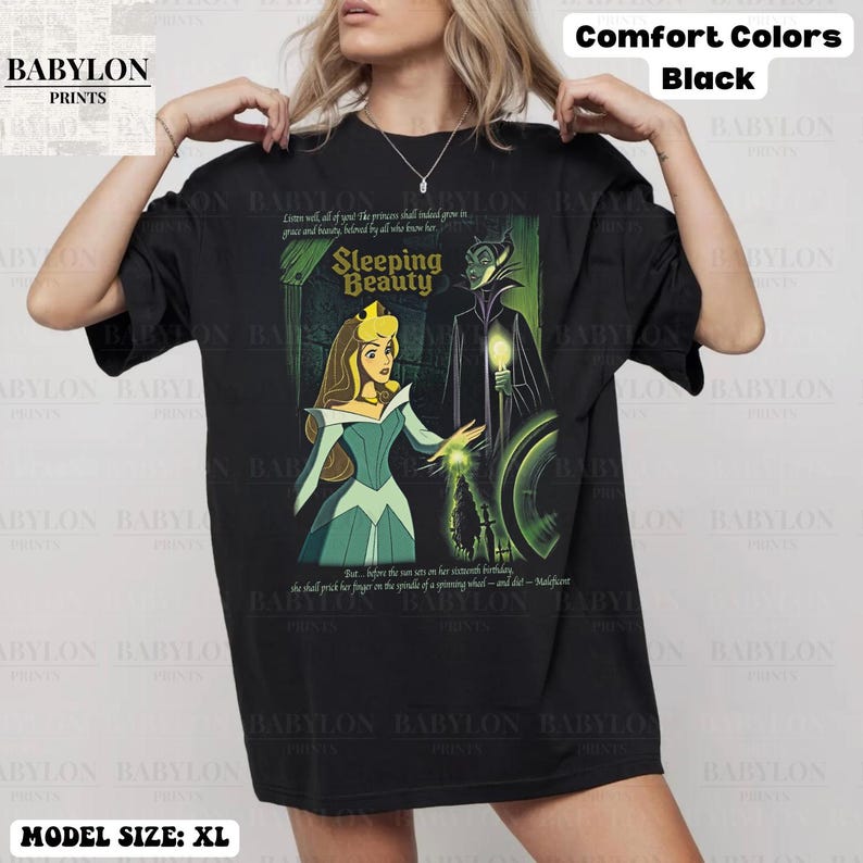 May include: Black XL t-shirt featuring a Sleeping Beauty graphic. The design includes Aurora, Maleficent, and text from the movie. The shirt is labeled "Comfort Colors" and "Babylon Prints".