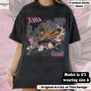 May include: Black t-shirt featuring a graphic of the X-Men character Gambit. The design includes Gambit with playing cards and the text "X-Men" and "Gambit". The shirt is a premium wash.