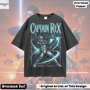 May include: Dark grey oversized t-shirt with a graphic of Captain Rex from Star Wars. The design includes the text "CAPTAIN REX" in a distressed font, with a detailed illustration of the character in action. The shirt also has the text "Oversized Tee!" and "Original Artist of This Design".
