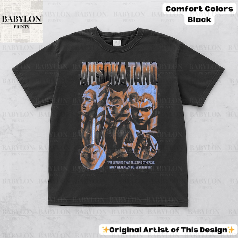 May include: Black t-shirt with a vintage-style graphic of Ahsoka Tano from Star Wars. The graphic features Ahsoka and other characters from the show. The text "I've learned that trusting others is not a weakness, but a strength." is printed below the graphic.