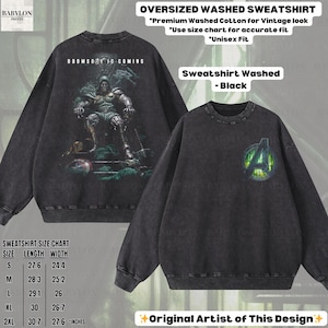 May include: Black oversized washed sweatshirt with a vintage look. The front features an Avengers logo, while the back displays a graphic of a character with the text "DOOMSDAY IS COMING". The sweatshirt is made of premium washed cotton.