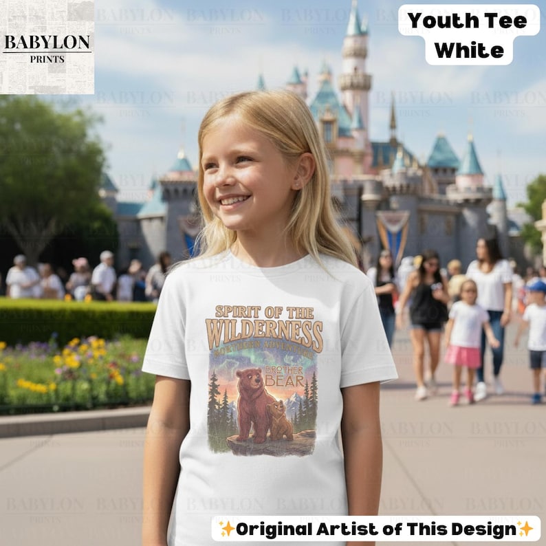 May include: White youth tee with a graphic of two bears and the text "Spirit of the Wilderness" and "Mother Bear". The design includes a sunset and aurora borealis. The shirt is from Babylon Prints.