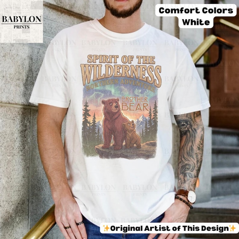 May include: White t-shirt with a graphic of two bears in a wilderness setting, with the words "Spirit of the Wilderness" and "Brother Bear." The shirt also has the text "Comfort Colors White" and "Original Artist of This Design."