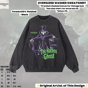 Puede incluir: Una sudadera negra lavada de corte oversize con un gr&aacute;fico de The Hatbox Ghost de Haunted Mansion. El dise&ntilde;o incluye texto e im&aacute;genes en morado y verde. La sudadera tiene cuello redondo y mangas largas, con una tabla de tallas en pulgadas.