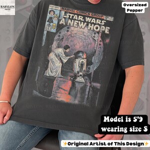 May include: Dark gray oversized t-shirt featuring a Star Wars comic book cover design. The graphic includes the text "STAR WARS A NEW HOPE" and images of characters. The shirt is a size S.