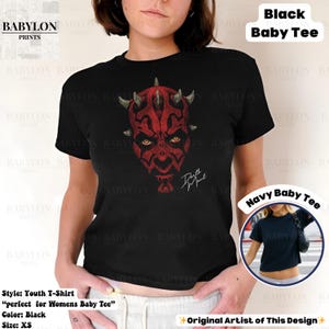 Może przedstawiać: Czarny t-shirt dla dziecka z czerwono-czarną grafiką twarzy postaci z rogami i ż&oacute;łtymi oczami. Koszulka ma napis "Darth Maul" w kolorze białym. Rozmiar młodzieżowy XS.