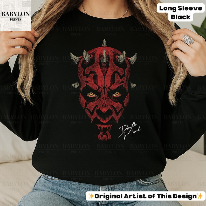 Może przedstawiać: Czarna koszulka z długim rękawem z czerwoną grafiką Darth Maul. Projekt przedstawia twarz postaci z rogami i imieniem "Darth Maul" w białym skrypcie. Koszulka ma napis "Long Sleeve Black" w prawym g&oacute;rnym rogu.