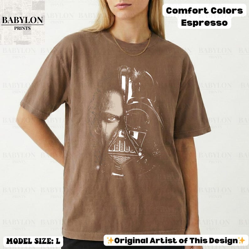 May include: Espresso-colored t-shirt featuring a split image of a character's face and a helmet. The shirt has the text "Comfort Colors Espresso" and "Original Artist of This Design". The brand logo "BABYLON PRINTS" is visible.
