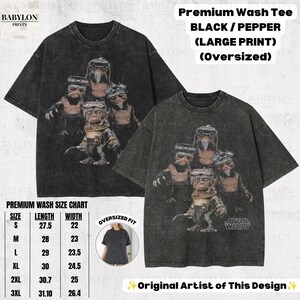 Op de afbeelding: Een oversized zwart en peperkleurig premium gewassen T-shirt met een grafische print van vier Ewok-personages uit Star Wars. Het shirt heeft een ronde hals en korte mouwen. Tekst op de afbeelding bevat Premium Wash Tee, Black / Pepper, Large Print, Oversized, Star Wars en een maattabel.