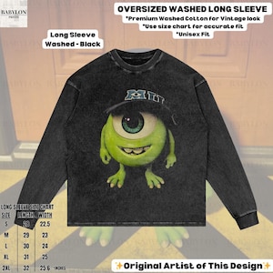 K&ouml;nnte beinhalten: Schwarzes Langarmshirt mit Used-Look und einem Aufdruck von Mike Wazowski aus Monster AG. Das Shirt hat den Text "MI" auf einer M&uuml;tze. Das Shirt ist oversized und aus hochwertiger gewaschener Baumwolle.