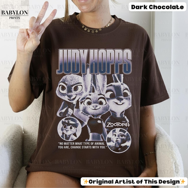 May include: Dark chocolate brown t-shirt featuring the text "JUDY HOPPS" above a graphic of characters from the movie Zootopia. The shirt also includes the quote, "NO MATTER WHAT TYPE OF ANIMAL YOU ARE, CHANGE STARTS WITH YOU."