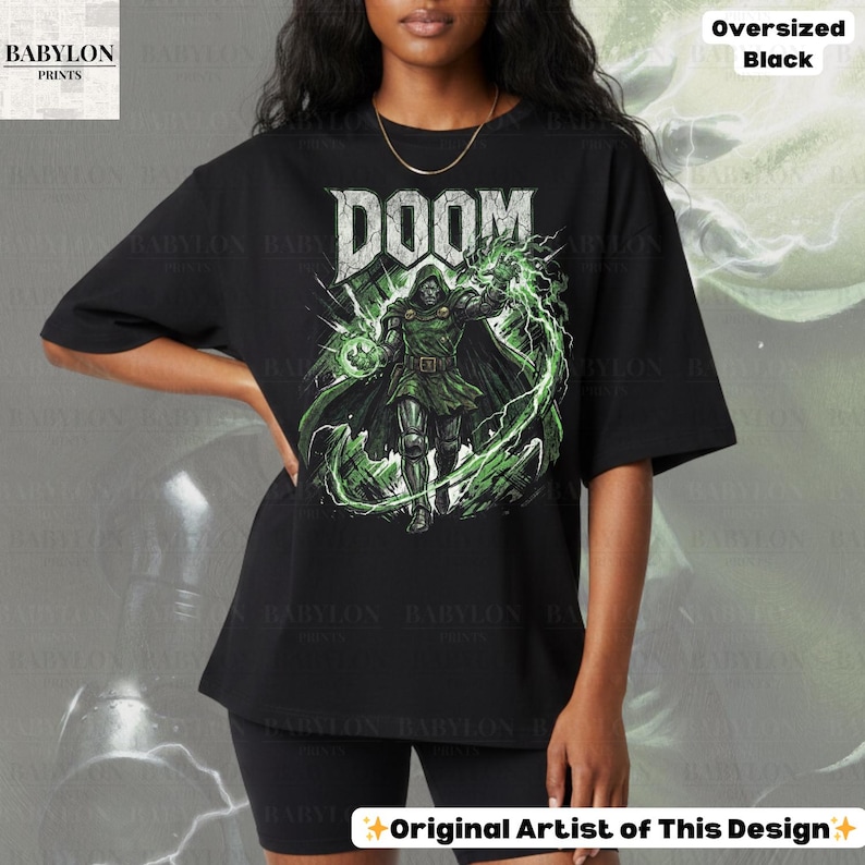May include: Black oversized t-shirt featuring the word "DOOM" in a bold, stylized font above a graphic of a character in a green and black outfit with green energy effects. The shirt is from Babylon Prints.