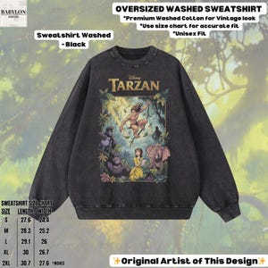 May include: Black oversized washed sweatshirt featuring a Tarzan graphic. The design includes Tarzan, Jane, gorillas, and an elephant. The sweatshirt has the text "Disney Tarzan" and a size chart.