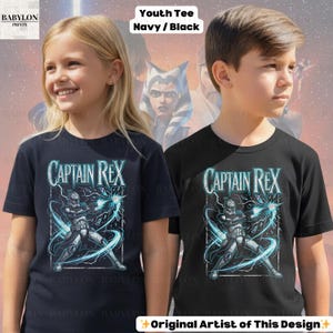 May include: Two youth t-shirts, navy and black, with the text "CAPTAIN REX". The graphic shows a character with blue energy effects. The shirts are labelled "Youth Tee Navy/Black" and are from "BABYLON PRINTS".