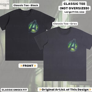 May include: Two classic unisex fit t-shirts, one black and one grey, each featuring a large print of a green and yellow Avengers logo. The shirts are labeled "Classic Tee" and "Original Artist of This Design."