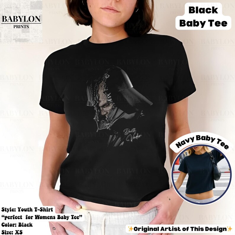 K&ouml;nnte beinhalten: Schwarzes Jugend-T-Shirt mit einer schwarz-wei&szlig;en Illustration von Darth Vader. Der Text "Darth Vader" ist kursiv geschrieben. Das Shirt ist im Baby-T-Shirt-Stil. Das Bild zeigt auch ein Navy Baby Tee.
