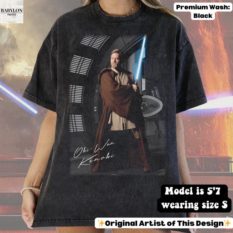 Może przedstawiać: Czarny t-shirt z grafiką Obi-Wana Kenobiego trzymającego miecz świetlny. Na koszulce napisano "Obi-Wan Kenobi" kursywą. Koszulka jest wysokiej jakości, a modelka ma 170 cm wzrostu i nosi rozmiar S.