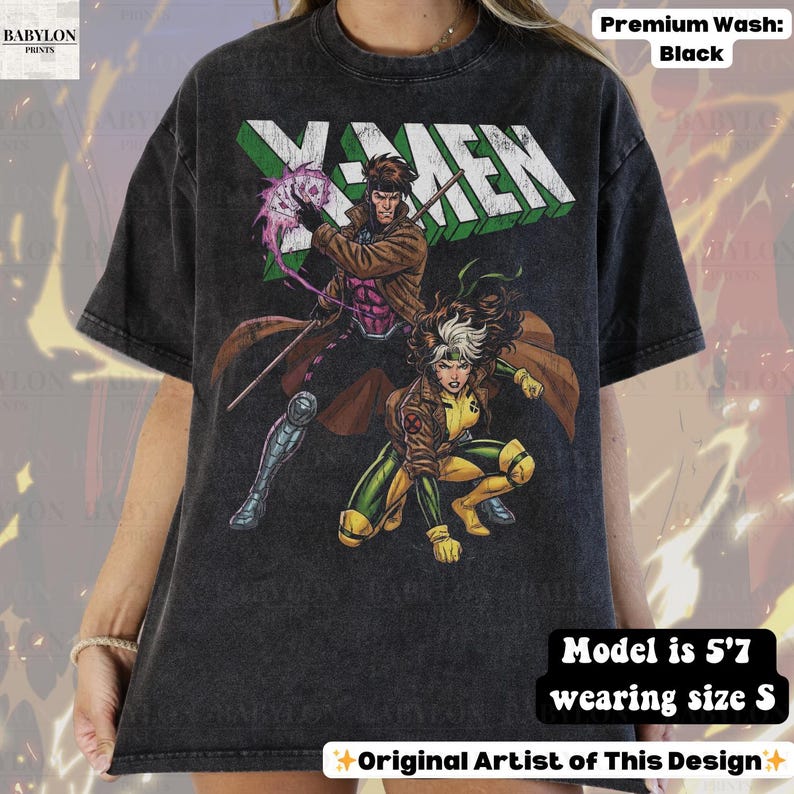May include: Black t-shirt featuring the X-Men logo and comic book characters Gambit and Rogue. The shirt has a distressed look and the text "Original Artist of This Design". The model is 5'7" and wearing a size S.