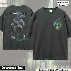 May include: Dark gray oversized tee shirt with a graphic of a character on the back with the text "DOOMSDAY IS COMING". The front of the shirt has a green and yellow Avengers logo. The shirt is labeled "Oversized Pepper" and "Oversized Tee!"