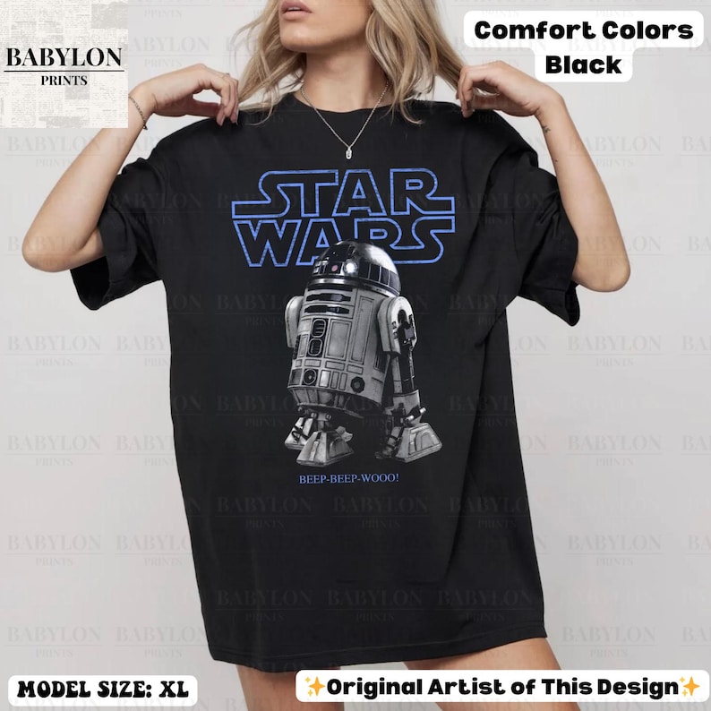 K&ouml;nnte beinhalten: Eine wei&szlig;e Keramik-Tasse mit schwarzem Henkel und dem Text "But First, Coffee" in schwarzer, handschriftlicher Schrift. Die Tasse steht auf einer wei&szlig;en Oberfl&auml;che.
