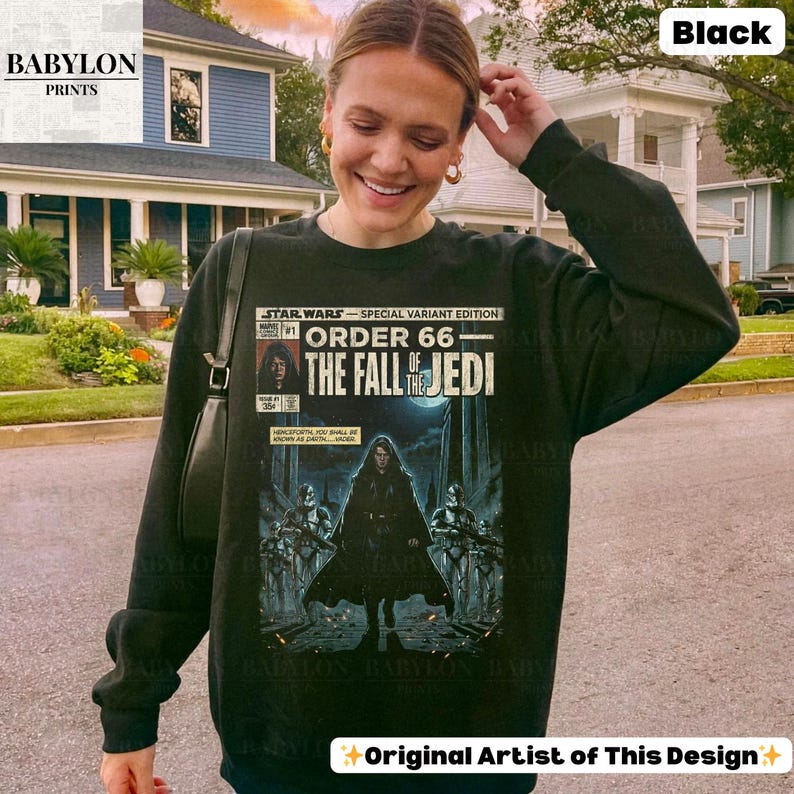 May include: Black sweatshirt featuring a Star Wars comic book cover design. The graphic reads "STAR WARS - SPECIAL VARIANT EDITION ORDER 66 - THE FALL OF THE JEDI." The sweatshirt has long sleeves and a crew neck.