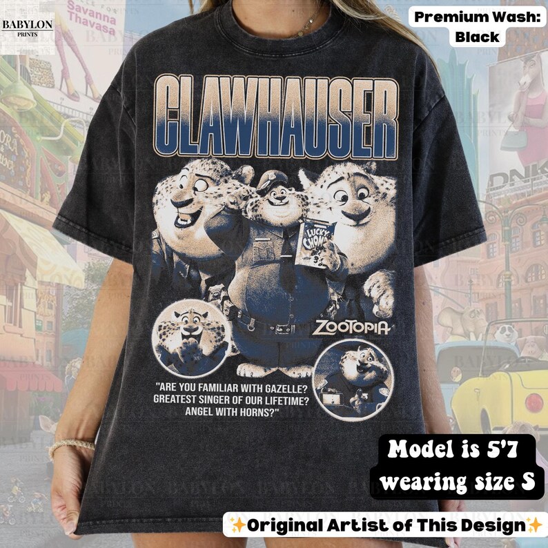 May include: Black t-shirt featuring the word "CLAWHAUSER" above a graphic of the Zootopia character Clawhauser. The shirt also includes the text "ZOOTOPIA" and the phrase "ARE YOU FAMILIAR WITH GAZELLE? GREATEST SINGER OF OUR LIFETIME? ANGEL WITH HORNS?"