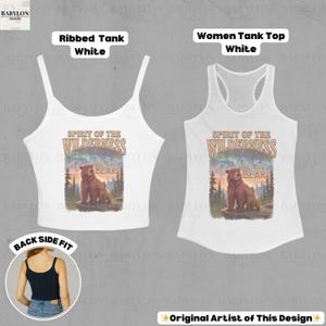May include: Two white tank tops, a ribbed style and a women's tank top, both displaying a graphic with the text "Spirit of the Wilderness" and a bear illustration. The tank tops have different strap designs.