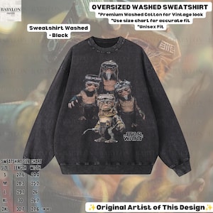 May include: An oversized black washed cotton sweatshirt featuring a graphic print of four Star Wars Ewok characters. The text reads OVERSIZED WASHED SWEATSHIRT, Premium Washed Cotton for Vintage look, Use size chart for accurate fit, Unisex Fit, and Star Wars.