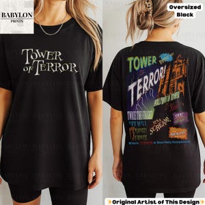 Op de afbeelding: Zwart oversized T-shirt met de tekst "TOWER OF TERROR" op de voor- en achterkant. De achterkant heeft een afbeelding van een spooktoren, bliksem en zinnen als "Twice the Fright" en "It's a Scream!"
