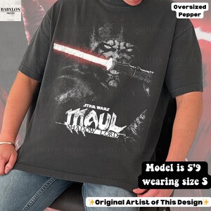 May include: Dark gray oversized t-shirt featuring a graphic of Darth Maul from Star Wars with a red lightsaber. The text "STAR WARS MAUL SHADOW LORD" is below the image. The shirt is a size S.