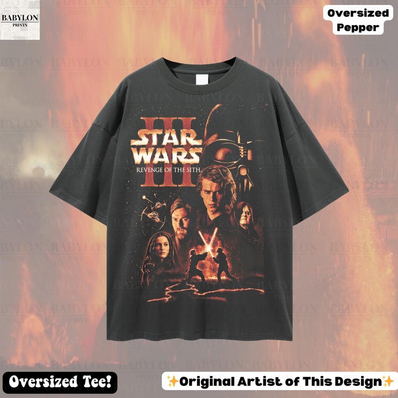 May include: Dark gray oversized t-shirt featuring a Star Wars III: Revenge of the Sith graphic. The design includes characters and the film's title in orange and white. The shirt has a crew neck and short sleeves.