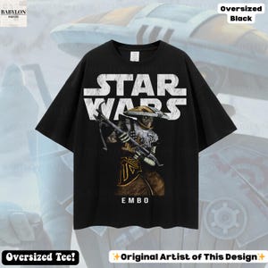 Puede incluir: Camiseta negra de gran tama&ntilde;o con el logotipo blanco de Star Wars y un gr&aacute;fico de Embo. El texto "EMBO" est&aacute; debajo. La camiseta est&aacute; etiquetada como "Oversized Black" y "Oversized Tee!"