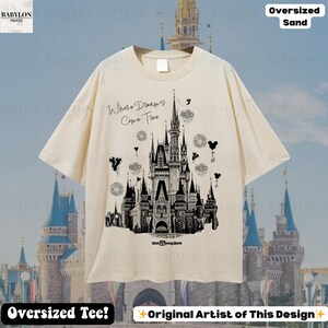 May include: Sand-coloured oversized tee with a black and white castle illustration and the text "Where Dreams Come True." The design includes "Walt Disney World" at the castle's base. The shirt also has the text "Oversized Tee!" and "Original Artist of This Design" at the bottom.