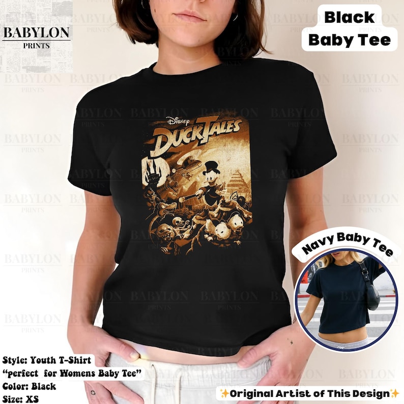May include: Black youth t-shirt featuring a vintage-style graphic from Disney's DuckTales. The design showcases Scrooge McDuck and other characters in sepia tones. The shirt is a baby tee style and is size XS.