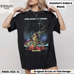 May include: Black oversized t-shirt featuring a Star Wars movie poster design. The graphic includes Japanese text and the phrase "STAR WARS シリーズ第2弾!" in white. The shirt is labeled "Comfort Colors" and the model is wearing size XL.