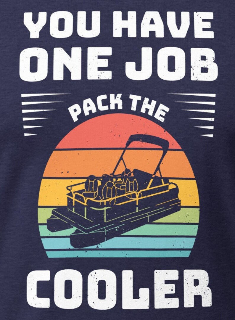 May include: A navy blue t-shirt with a white graphic design that says "You have one job pack the cooler". The graphic features a retro sunset with a pontoon boat in the center.