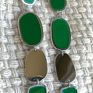 May include: A set of three ceramic mugs with a speckled, matte finish. The mugs are in shades of cream, light gray, and dark gray. Each mug has a simple, minimalist design and a rounded handle.