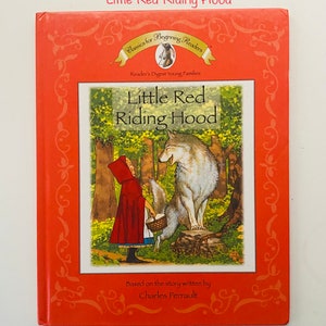 May include: A vintage children's book titled "Little Red Riding Hood" by Reader's Digest Young Families. The cover features an illustration of the story's characters: Little Red Riding Hood and a wolf in a forest setting. The book has a red cover with decorative borders.