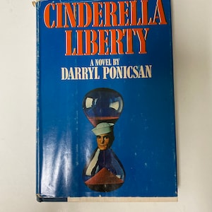 May include: A vintage book titled "Cinderella Liberty" by Darryl Ponicsan. The cover is blue with orange text and an hourglass illustration featuring a man in a sailor's hat. The book has visible wear and tear.
